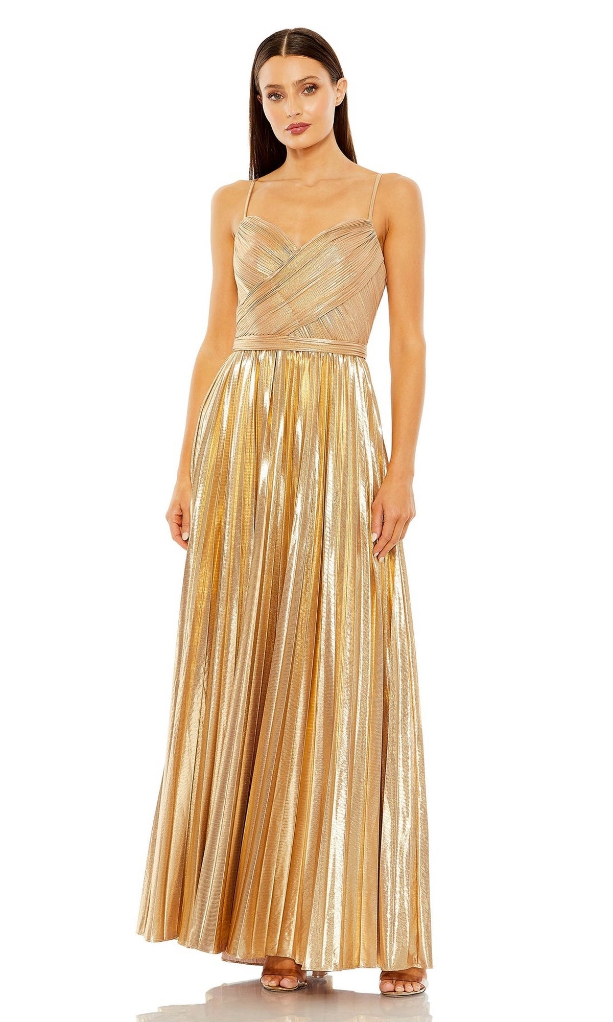 A woman stands against a white background wearing the Long Formal Dress 27489 by Mac Duggal, a floor-length gold metallic pleated A-line gown with thin straps.